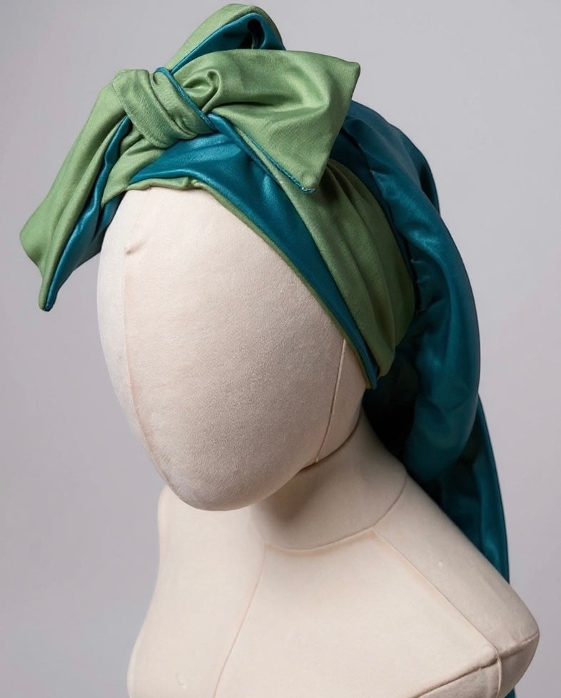 AQueenzDen reversible double layer satin bonnet in green and teal with adjustable ties tied in a bow.