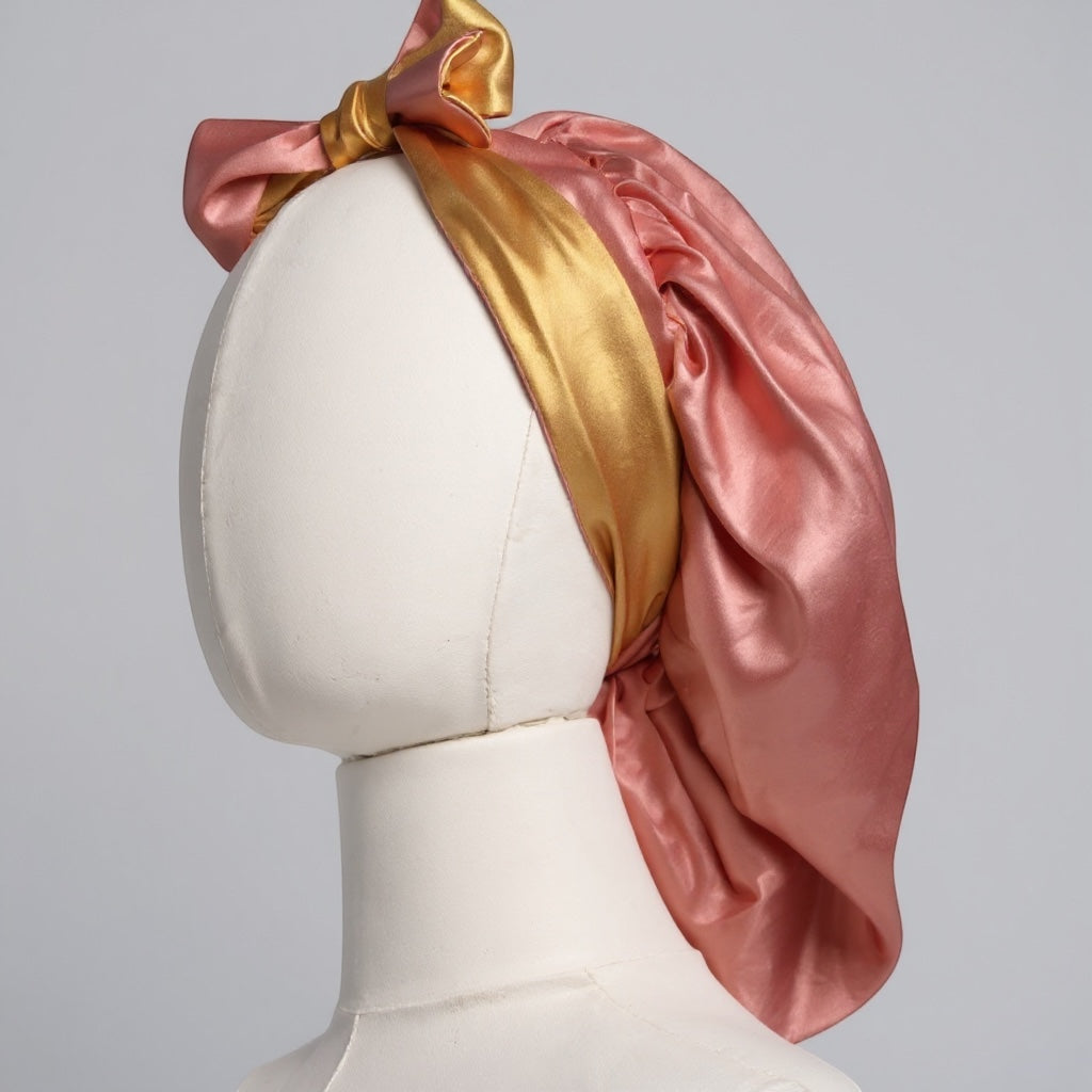 AQueenzDen double layer reversible satin bonnet in pink and gold with adjustable ties and a bow. Silky material.