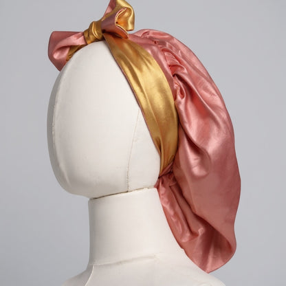 AQueenzDen double layer reversible satin bonnet in pink and gold with adjustable ties and a bow. Silky material.