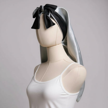 AQueenzDen reversible double layer satin bonnet in silver and black with adjustable ties and a bow detail.