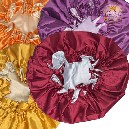 A Queenz Den adjustable double layer reversible satin bonnet in burgundy, purple, orange, and gold.
