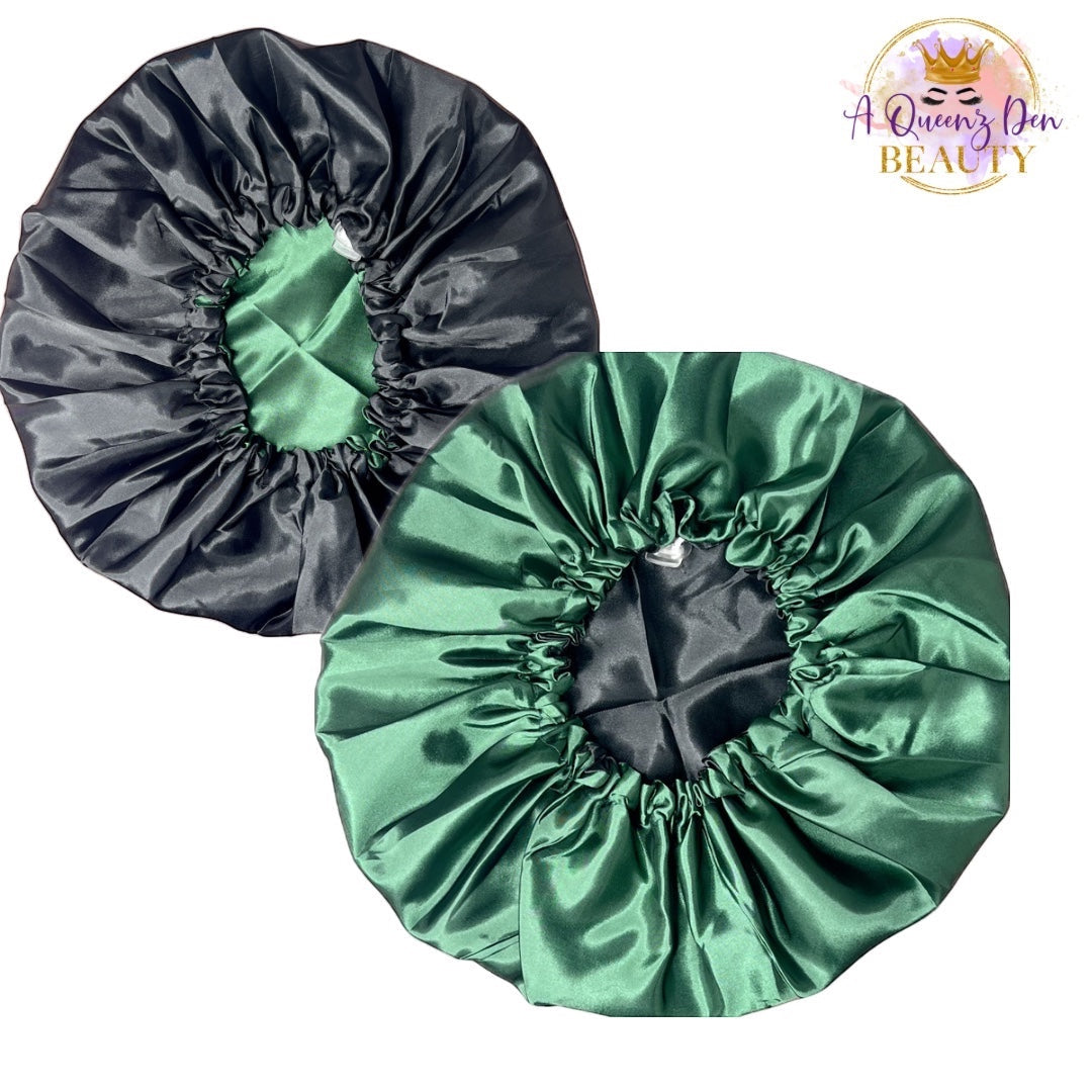 A Queenz Den reversible satin bonnet in black and emerald green. Features adjustable tie and double layer protection for natural hair.